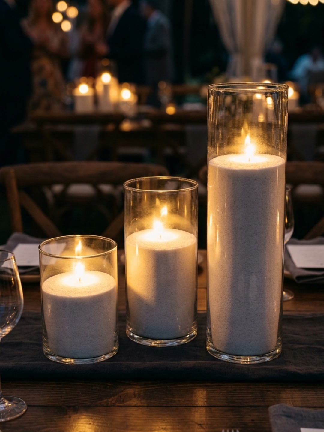 Wedding reception candles styled in clear glass vessels